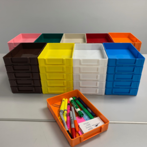 A group of colored drawers with pens and pencils in them.