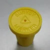 A yellow bottle cap sitting on top of a table.