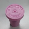 A pink bottle cap sitting on top of a table.