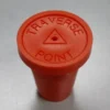 A red bottle cap sitting on top of a table.