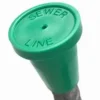 A green sewer line marker sitting on top of a pipe.